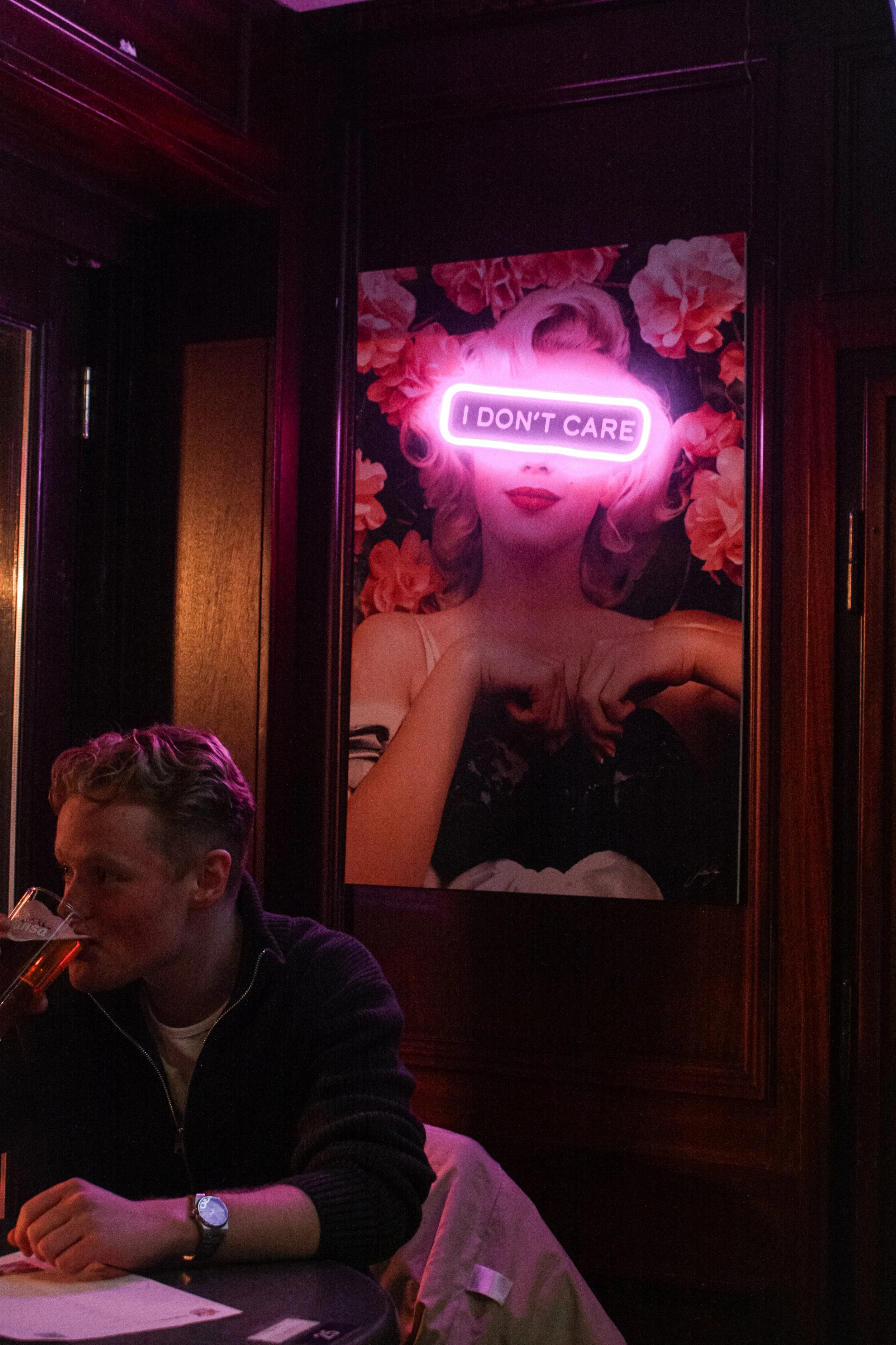 Mørkt nattklubb-hjørne med rosa neon-skilt og treverk-panel hos Metz Bergen.